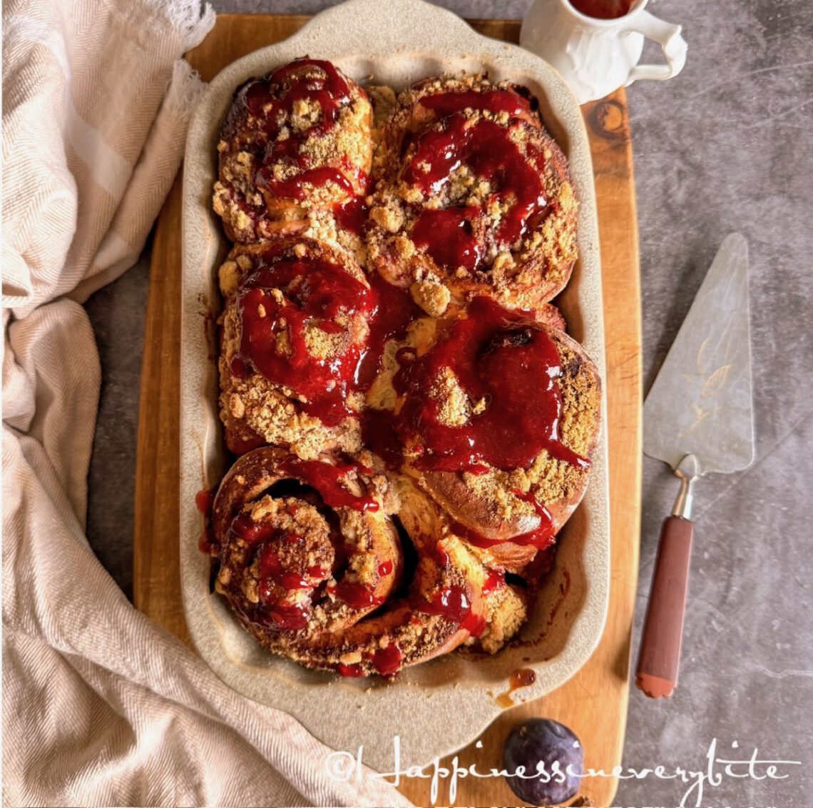 Cinnamon rolls with plum jam and marzipan crumbs